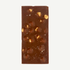 Milk chocolate block showing roasted hazelnuts, caramel crunch pieces and sea salt crystals