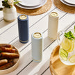 Navy blue Saucie bottle on dining table filled with sauce – reusable and modern kitchenware