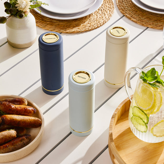 Navy blue Saucie bottle on dining table filled with sauce – reusable and modern kitchenware