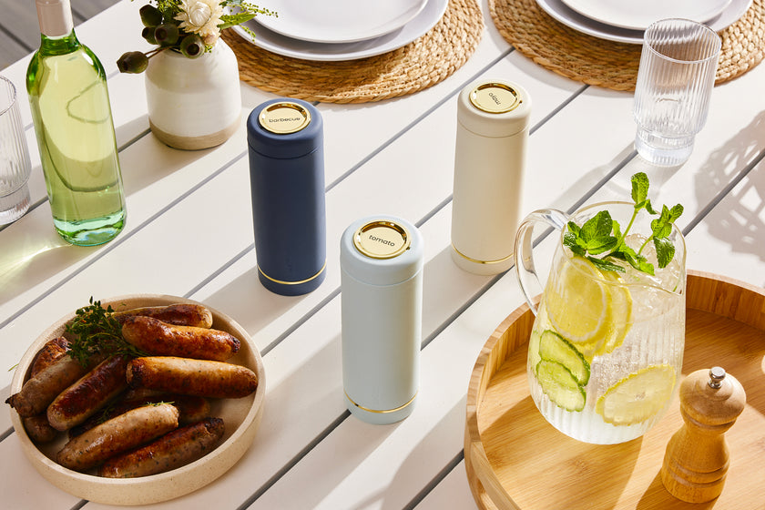 Navy blue Saucie bottle on dining table filled with sauce – reusable and modern kitchenware