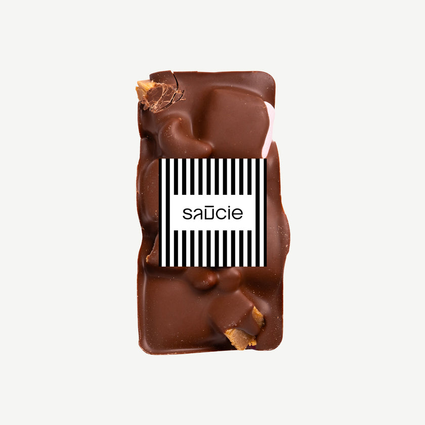 Gluten free milk chocolate rocky road served on a plate – handmade block with hazelnuts, fudge, marshmallows and raspberry lollies