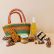 Woven basket with a bottle of white wine, jars of food, and pretzels on a beige background