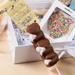 New Baby Hamper displayed on table – premium gift for new parents with chocolates and plush toy