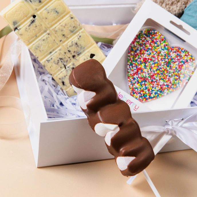 New Baby Hamper displayed on table – premium gift for new parents with chocolates and plush toy