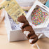 New Baby Hamper displayed on table – premium gift for new parents with chocolates and plush toy