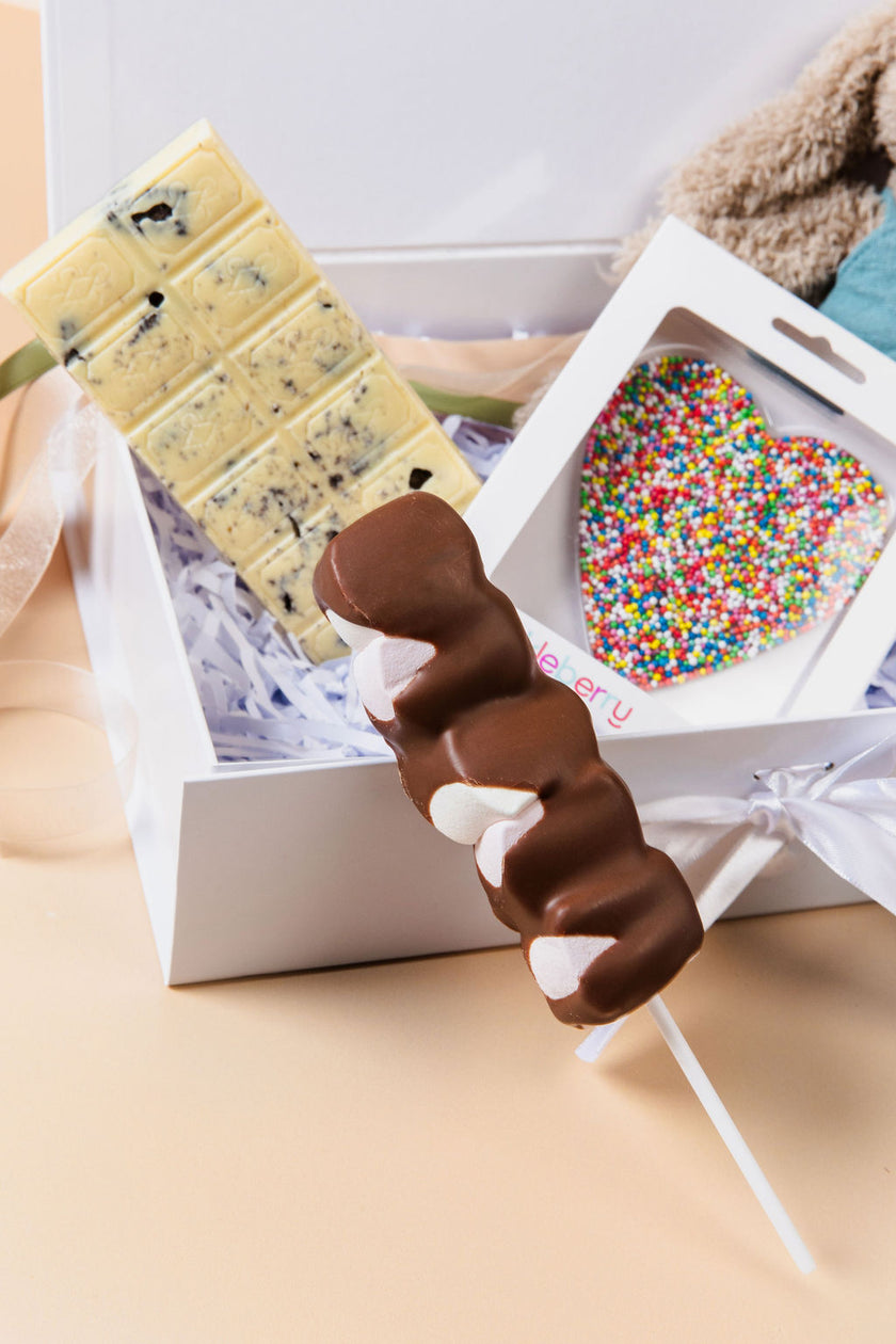 New Baby Hamper displayed on table – premium gift for new parents with chocolates and plush toy