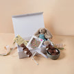 Gift box with plush toys, a small basket, and a decorative item on a beige background