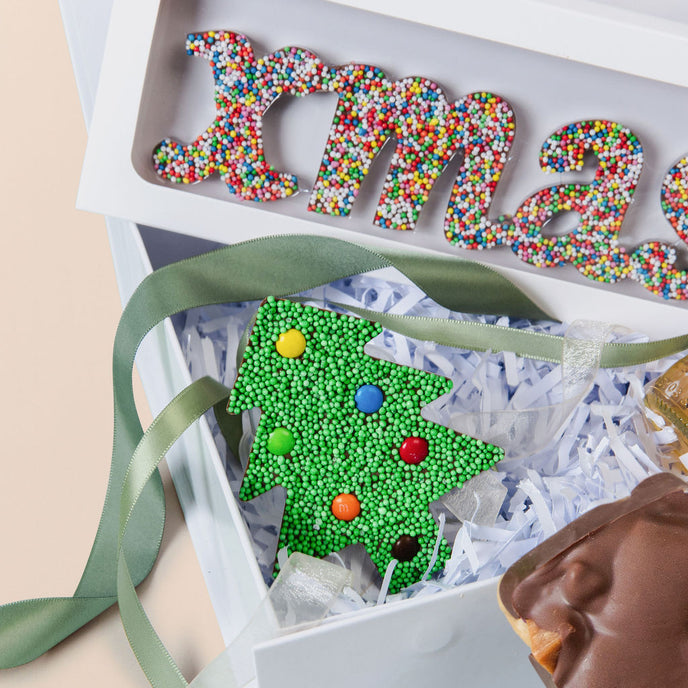Decorative Christmas-themed box with colorful letters and a tree design, featuring Freckleberry branding.