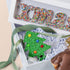 Decorative Christmas-themed box with colorful letters and a tree design, featuring Freckleberry branding.