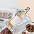 Gift box with a bottle of wine, cookies, and chocolates on a light background