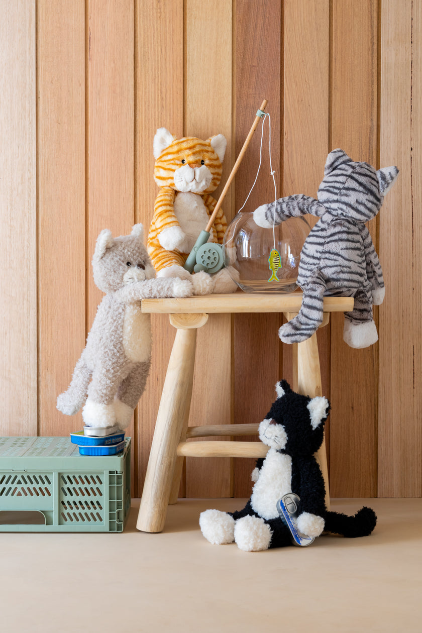 Plush toys on a wooden stool against a wooden paneled wall