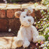 Stuffed dog toy on a brick step with flowers