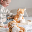 Child playing with plush tiger toys on a bed
