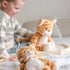 Child playing with plush tiger toys on a bed