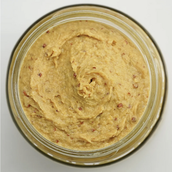 Jar of creamy spreadable food on a white background