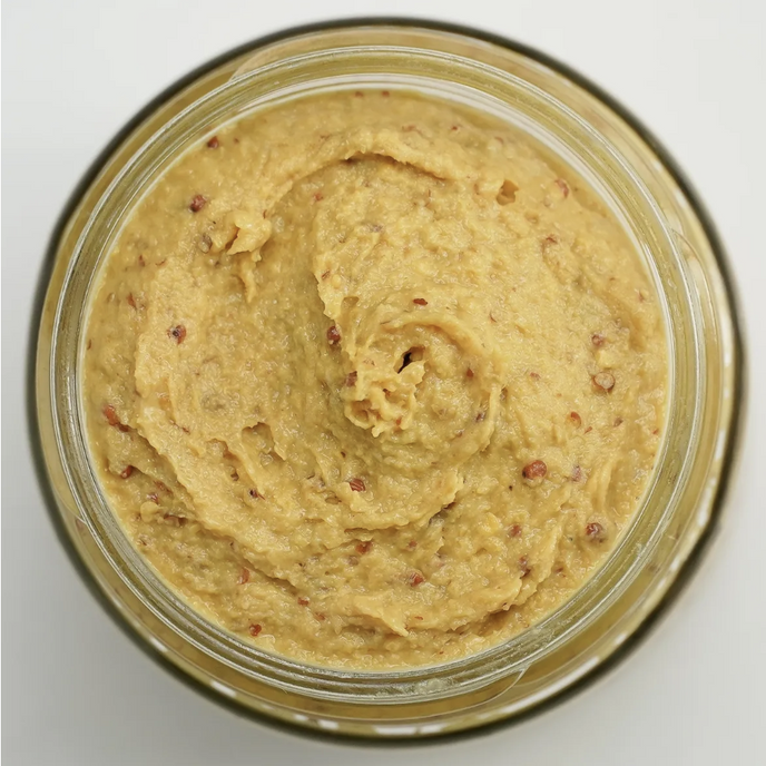 Jar of creamy spreadable food on a white background