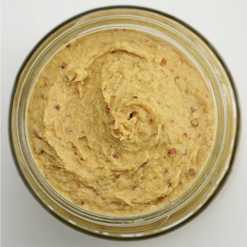 Jar of creamy spreadable food on a white background