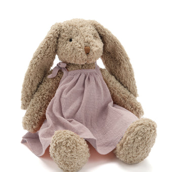 Plush bunny toy with a pink dress on a white background. Perfect for newborns or kids. Soft and cuddly