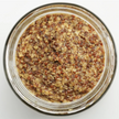 Close-up of a glass jar filled with a honey mustard on a white background