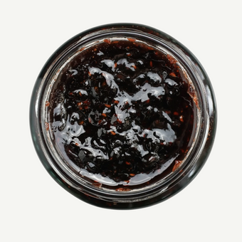 Jar of dark jam on a white background