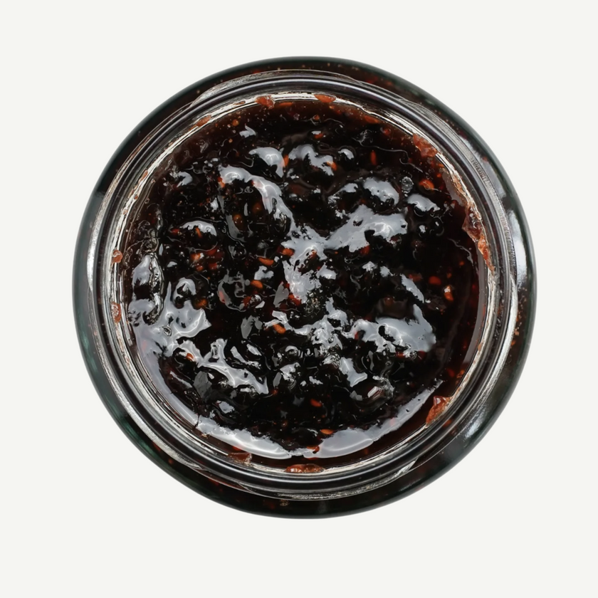 Jar of dark jam on a white background