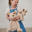 Young girl holding two teddy dogs against a plain background