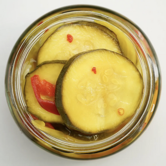 Jar of pickled cucumbers with a white background