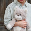 Child holding a teddy bear in an outdoor setting