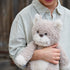 Child holding a teddy bear in an outdoor setting
