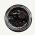 Top-down view of a jar of dark jelly or jam on a white background