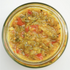 A jar of zucchini pickle with visible zucchini pieces, red pepper, and spices.