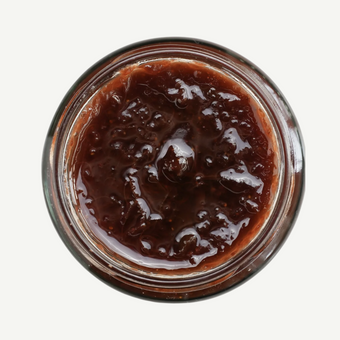 Jar of dark brown jam on a white background