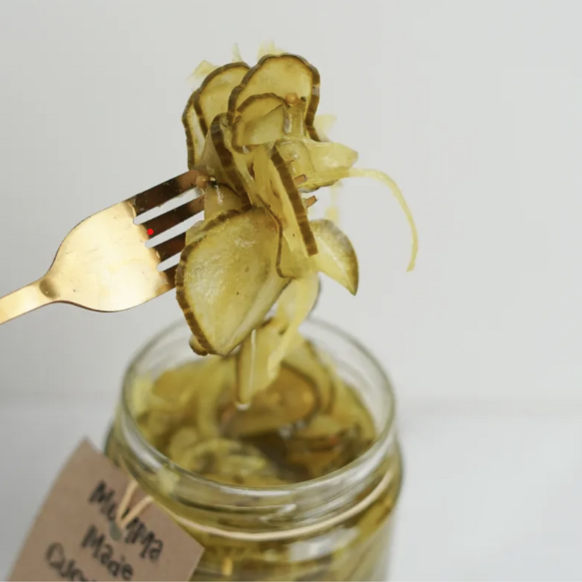 A jar of homemade cucumber pickles with a fork lifting some out of the jar, labeled with 'Homemade'.