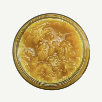 Jar of yellow fruit preserve on a white background