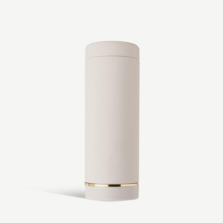 A tall, cylindrical white sauce condiments bottle with a gold band near the bottom.