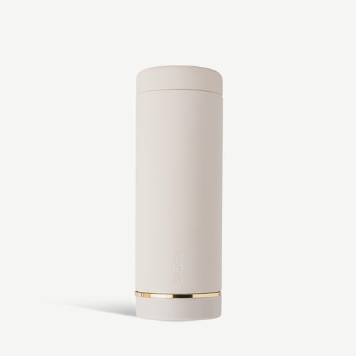 A tall, cylindrical white sauce condiments bottle with a gold band near the bottom.
