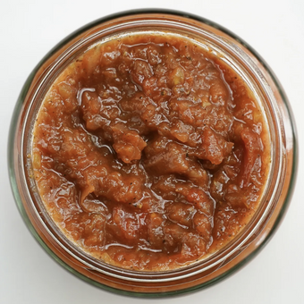 Jar of brown spreadable food on a white background