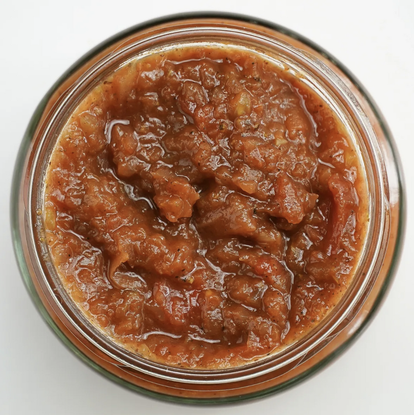 Jar of brown spreadable food on a white background
