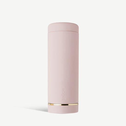 A cylindrical blush pink reusable sauce condiments bottle with a gold accent at the base.