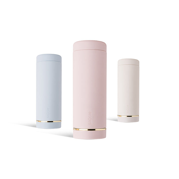 Three Saucie Bottles displayed on a dining table with colourful sauces inside