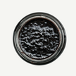 Close-up of a jar with black substance on a white background