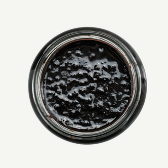 Close-up of a jar with black substance on a white background