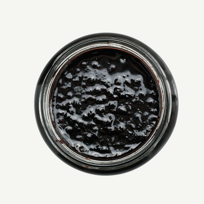 Close-up of a jar with black substance on a white background