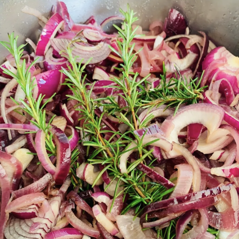 Sliced red onions with rosemary in a pot