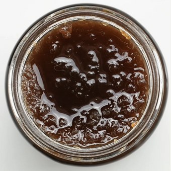 Close-up of a jar with a pear paste on a white background