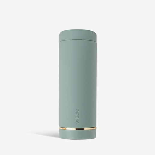 A cylindrical sage green reusable condiments sauce  bottle with a cap and a gold accent near the base.