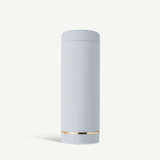 A cylindrical sky blue sauce condiments bottle with a gold band at the base.